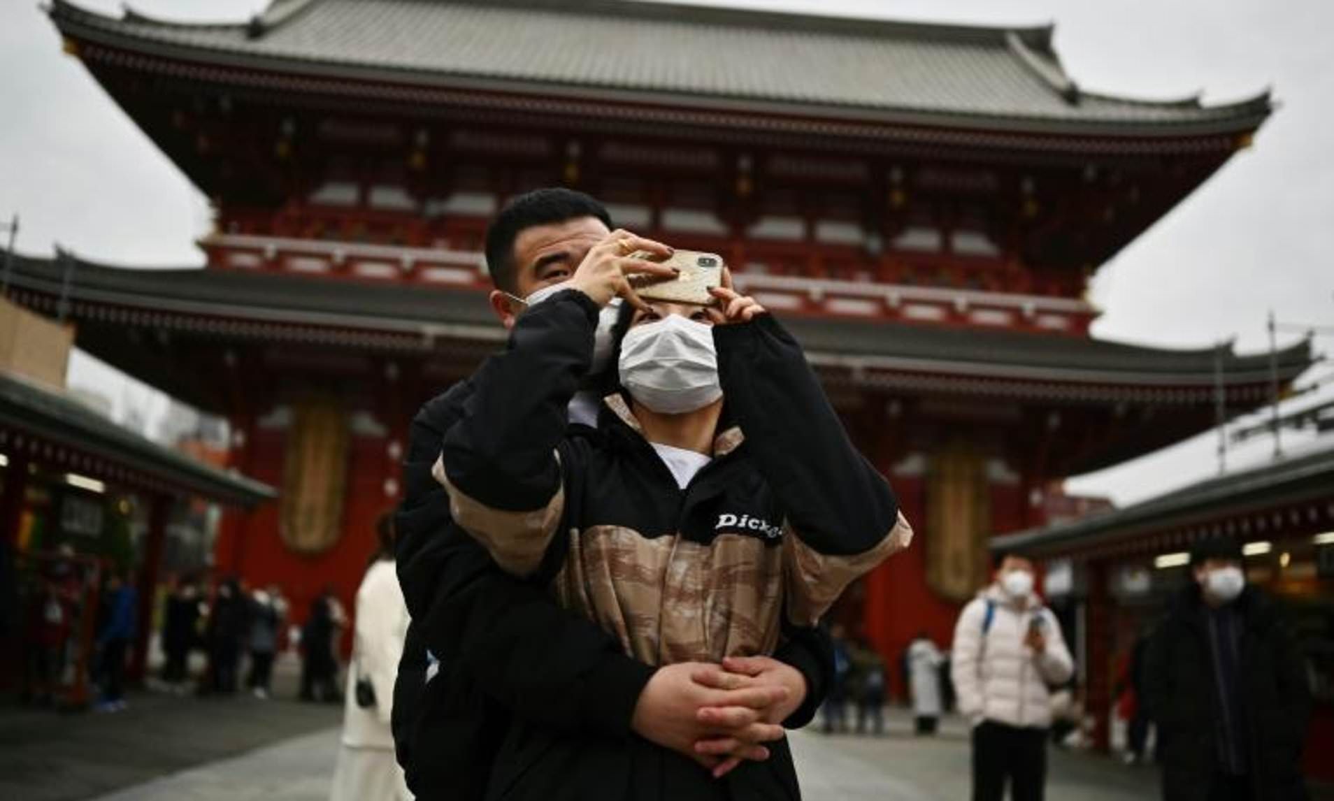 Residentes de Tóquio usando máscaras do lado de fora do santuário